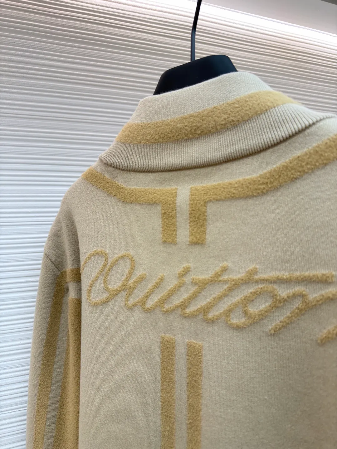LOUIS VUITTON two-color splicing intarsia zipper jacket ●Original version: purchased and developed at 20700 ●Item number: 1681968-C15 ●Fabric: nylon fabric ●Technology: intarsia production ●Color: khaki ●Version: fitted version ●Weight: about 1020 grams ●Size: XS-S-M-L ●Description: Made of 43% nylon, 32% cotton and 25% viscose blended fabric, which has both comfort and stiffness. The designer used two-tone intarsia technology to allow contrasting color strips to run through the sleeves and body, forming a smooth visual extension. Different areas create subtle three-dimensional texture effects by changing knitting density and stitching methods. The chest is decorated with a delicate intarsia LV logo, and the Vuitton word is presented in elegant font on the back, showing brand recognition in every detail. The collar, cuffs and hem made of rib knitting technology not only enhance the stability of the silhouette, but also echo the overall design language. The front placket features a smooth zipper closure and practical slip pockets on both sides for added functionality. The entire piece perfectly interprets the exquisite aesthetics of sports and leisure style through the ingenious combination of fabric texture and craftsmanship details. The overall wiring is straight and delicate, the fabric is comfortable and soft, and the color is consistent without color difference. It can be matched with the same style to create a fashionable look and control various occasions. Customized accessories, complete with three standards, same style for men and women!